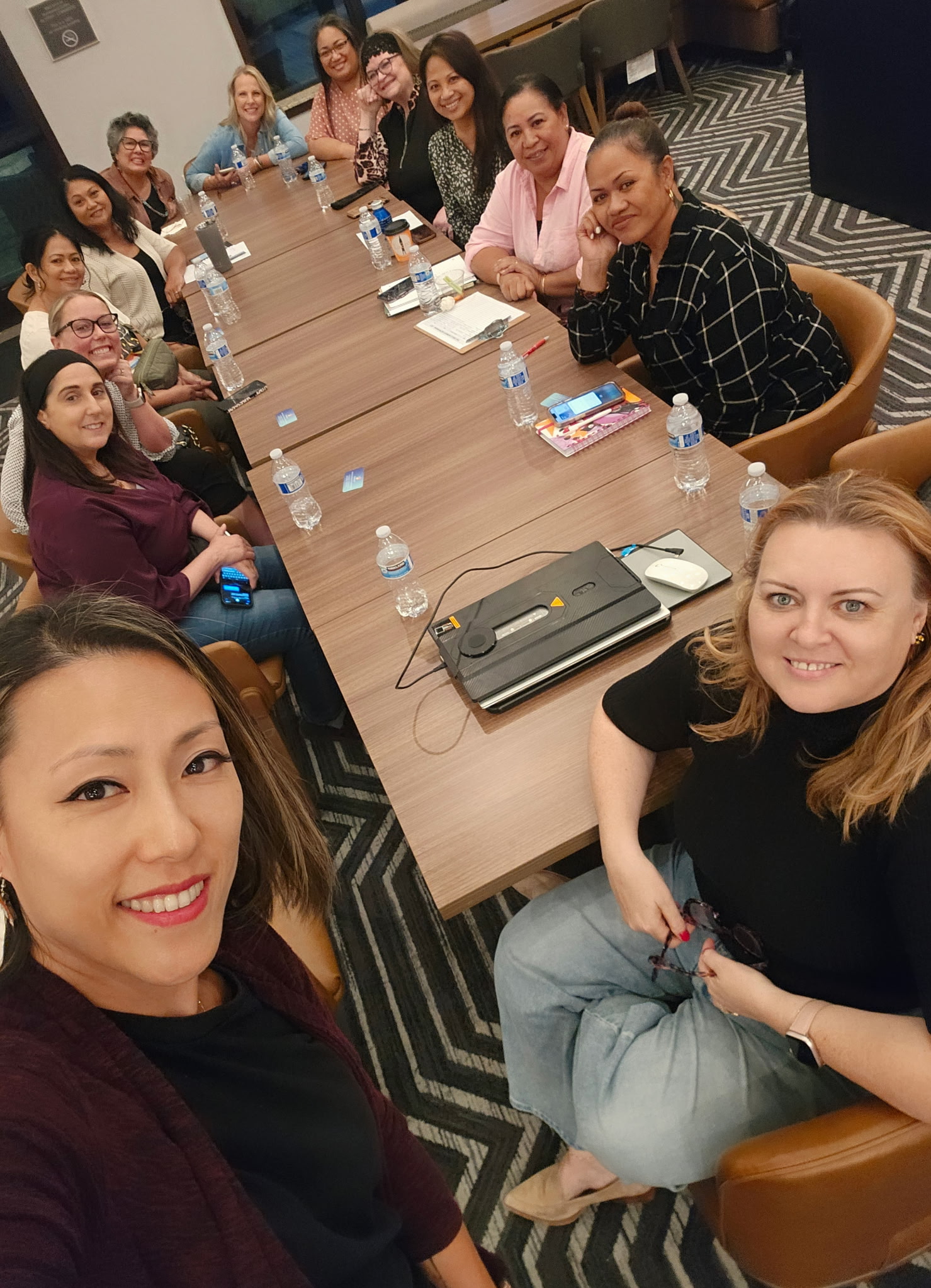 Circle attendees taking a group photo around a table